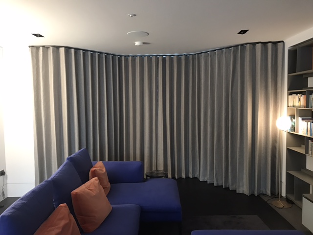 Closed grey wave curtains on shaped pole