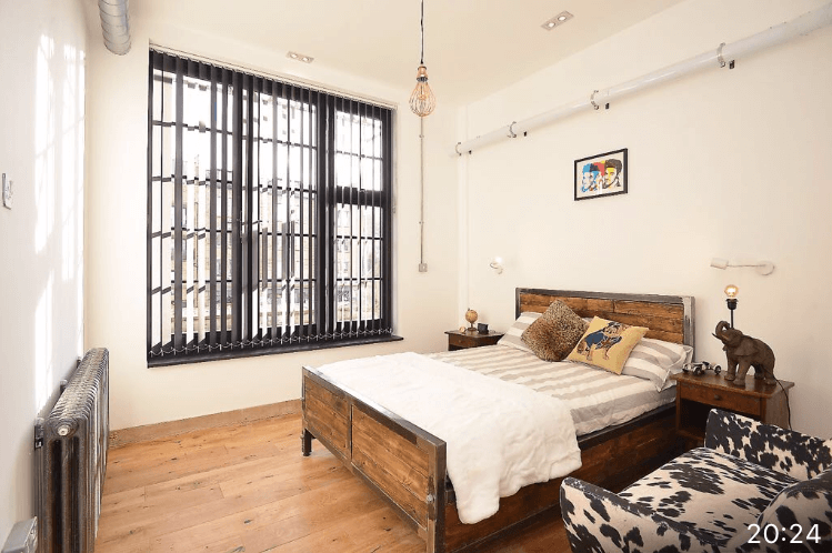 Bedroom with black slatted vertical blinds