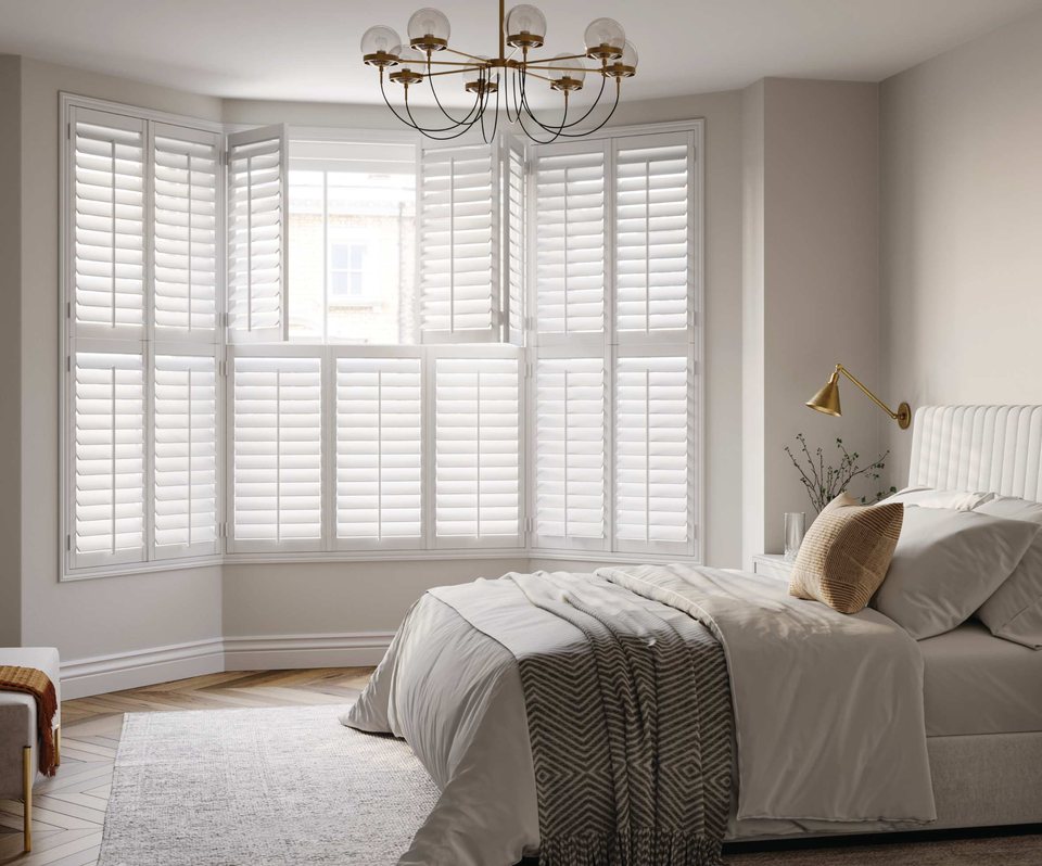 White Austin hardwood shutters across bedroom bay windows