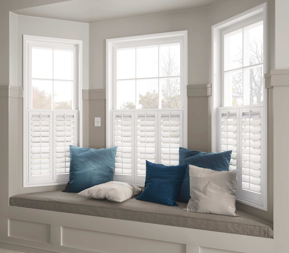 White café-style shutters covering the lower half of bay windows