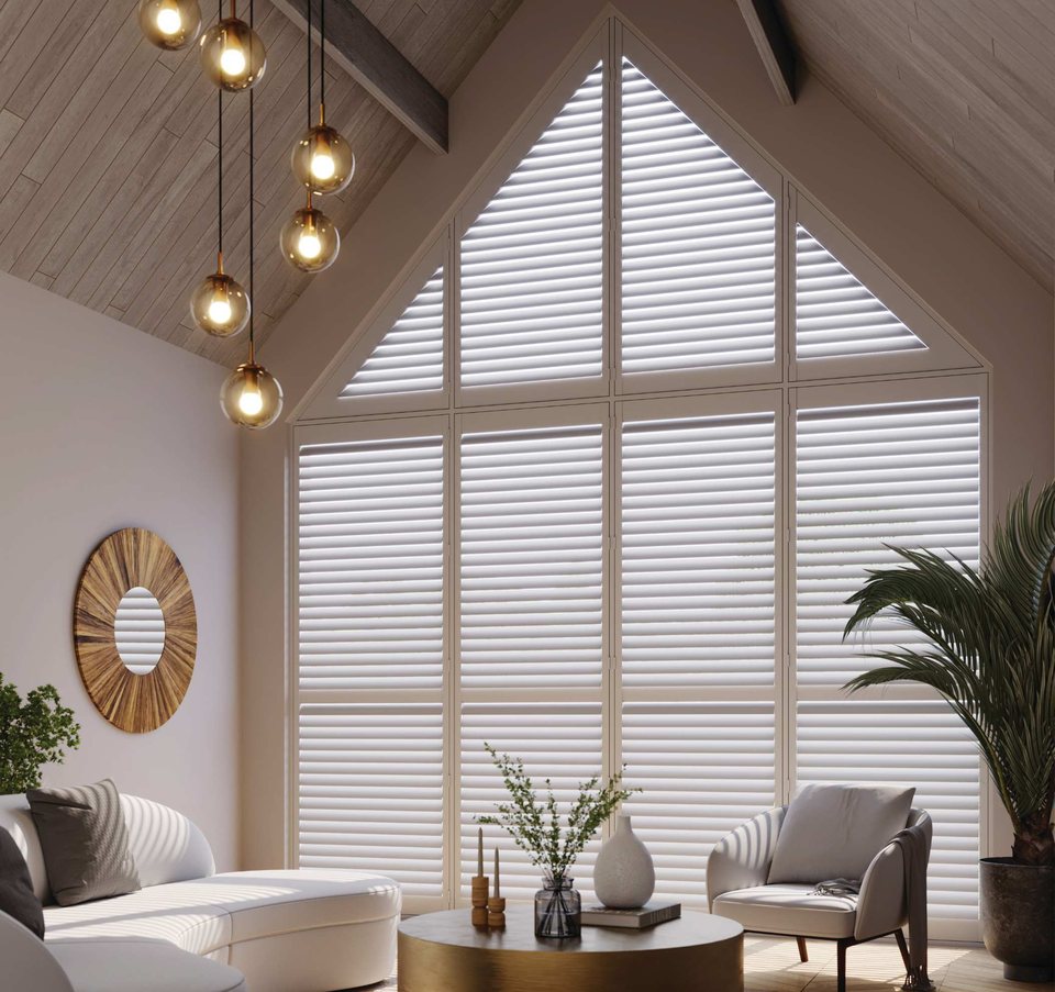 White shaped hardwood shutters in a triangular window