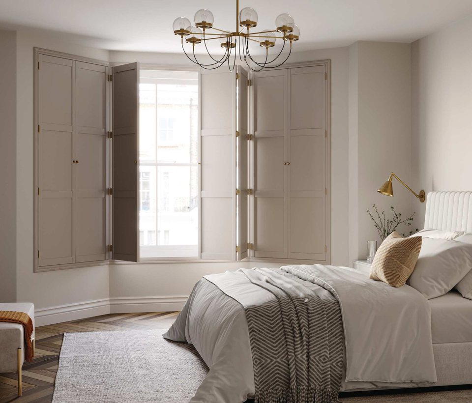 Open solid hardwood shutter panels in a bedroom