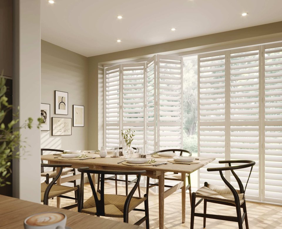 White tracked shutters behind a dining table